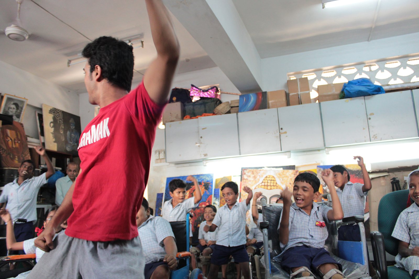 A choreographer from Shiamak Davar's institute leading a dance workshop, arm raised, with students following along