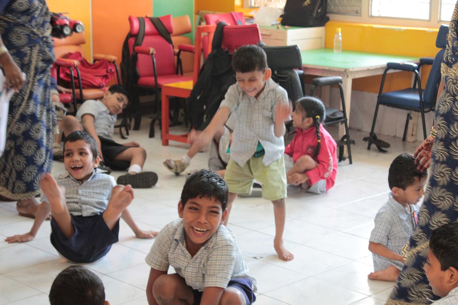 Students playing together on the floor of a brightly painted classroom