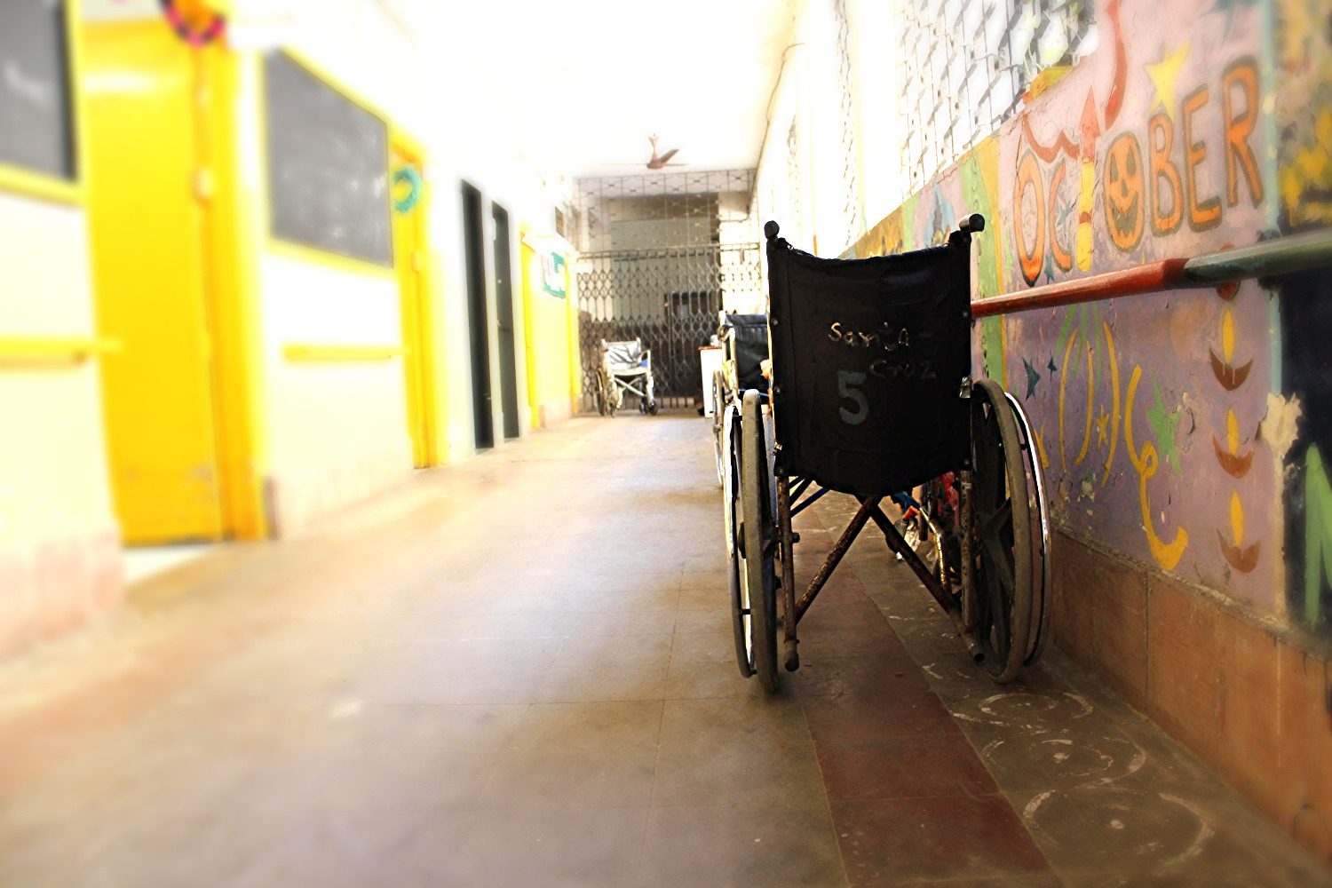 A wheelchair in a brightly painted, accessible school hallway
